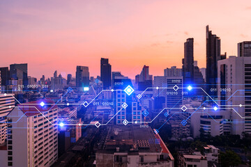 Glowing hologram of technological process, aerial panoramic cityscape of Bangkok at sunset. The largest innovative hub of tech services in Asia. Multi exposure.