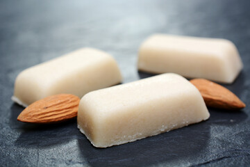 Marzipan und Mandeln zu Weihnachten auf grauer Platte aus Schiefer