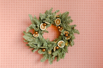 Christmas / New Year composition. Festive wreath made of christmas tree, fir branches against wall. Minimal winter holidays concept.