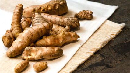Whole Turmeric roots at white fabric