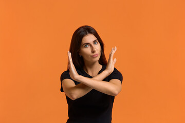 Stop it, please. Serious caucasian woman in black t-shirt crosses hands over chest, makes stop...