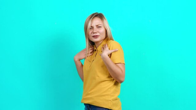 side view from the back with a young woman with a face who asks what Beautiful Caucasian woman in yellow T-shirt and long blond hair standing on blue background. A little fat teenager. Advertising