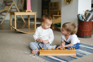 Toddlers children play together with noise cylinders, developing sensory and sports activities in...
