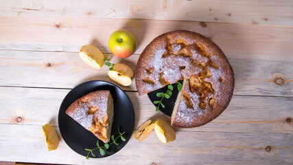 Charlotte, Apple pie with mint sprigs, Apple, Apple slices in a black plate on a wooden table, copy...