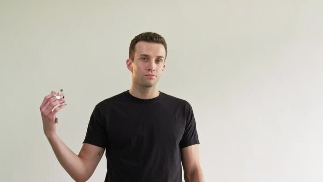 Failure crisis. Loser man. Ruined fun. Sad party. Depressed miserable lonely hopeless guy in black t-shirt throwing confetti isolated on light neutral copy space background.