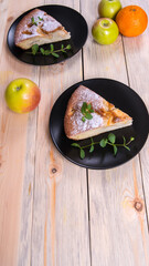 Charlotte, Apple pie with mint sprigs, orange slices and an Apple in a black plate on a wooden table, copy space, close-up, photos,