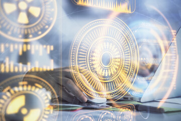 Technology theme hologram with man working on computer on background. High tech concept. Double exposure.