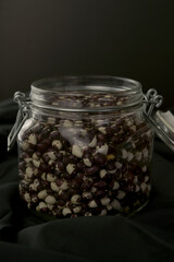 jar of beans and legumes on black background