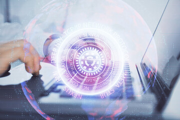 Technology theme hologram with man working on computer on background. High tech concept. Double exposure.