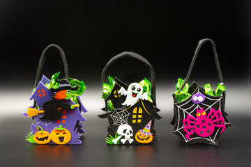 Halloween Candy Bags Cute Felt Pouches with Handles, Trick or Treat Goody Bags on black background.