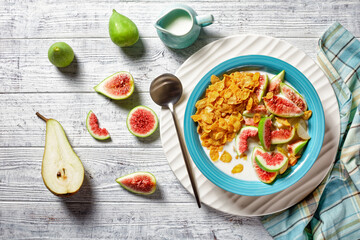 Blue bowl with yogurt, cornflakes, figs, pear