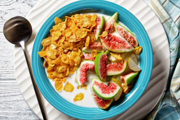 Blue bowl with yogurt, cornflakes, figs, pear
