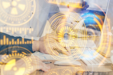 Technology theme hologram with man working on computer on background. High tech concept. Multi exposure.