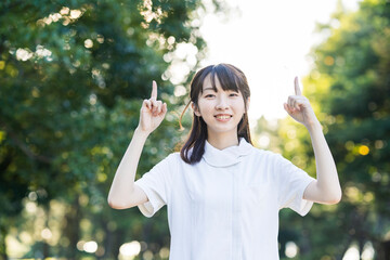 指差しポーズをする白衣の女性