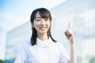 指差しポーズをする白衣の女性