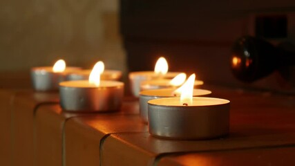 Advent candles near fireplace burning in shallow focus in darkness. Candles on mantel of fireplace as romantic background
