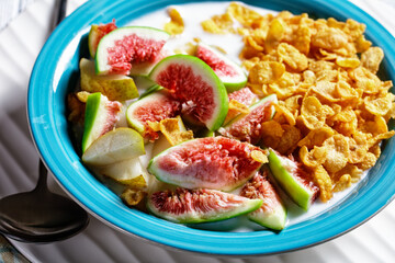 Blue bowl with yogurt, cornflakes, figs, pear