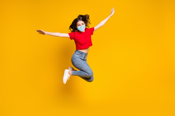 Fototapeta na wymiar Full size photo of crazy cheerful girl jump hold hand wear mask isolated over vivid color background
