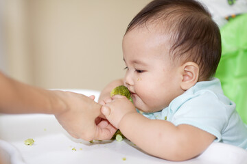 Cute Baby Eating On The Baby Chair