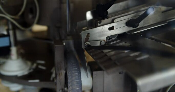 Automatic Tube Filling And Sealing Machine For Cosmetic Creams - Empty Plastic Tubes From The Loader Put On The Tube Mold By The Tunnel.  - close up