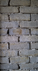 Unfinished bricks house wall background texture at the construction site. Grey ruined industrial brick wall with copy space. Interior and vintage design concept.