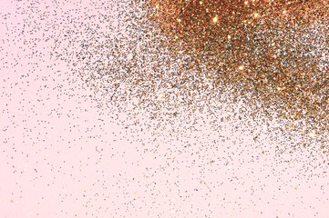 Gold glitter on light pink background. Beauty, cosmetics, holidays, party concept