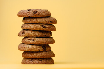 Pile of chocolate chip cookies on yellow backgreound