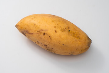 Disease mango on a white background, a black spot on the surface of the mango is often referred to as anthracnose.