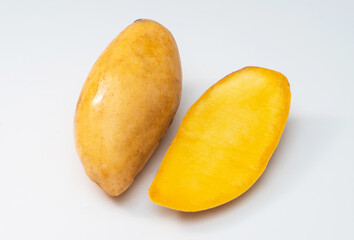 Haft of ripe mango on a white background, tropical fruit.