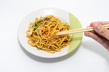 Was holding the chopsticks to pick up the Chinese-Styled Fried Noodle on a white background, Vegetarian Festival.