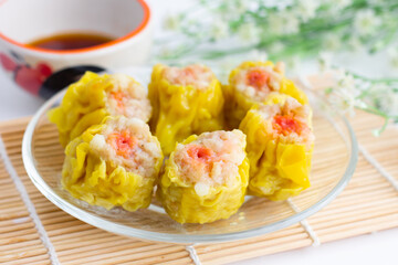 Chinese steamed dumpling 6 piece on dish and sour sauce.