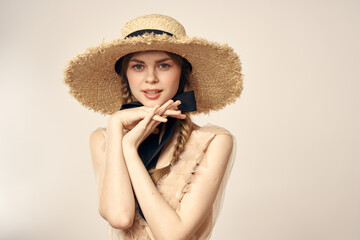 romantic girl in beige dress and in straw hat with black ribbon emotions portrait of model cropped view