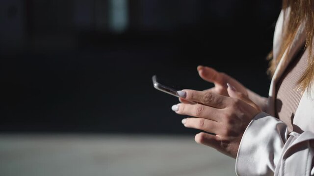 closeup female hand prints smartphone on the street, sending a message, writing notes. High quality 4k footage