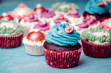 Very nice composition of cupcakes and cakepops with deocrations, colorful, blue background