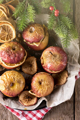 Obraz na płótnie Canvas Homemade Oven Baked Apples Stuffed with Nuts Orange Chips and Honey in Baking Pan Old Wooden Background Healthy Autumn or Christmas Dessert Vertical Top View