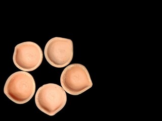 Mud clay diya arranged on black background top view.