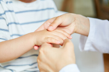 Osteopath macht Akupressur an der Hand von Kind