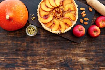 Apple tart pie and red apples on wooden table
