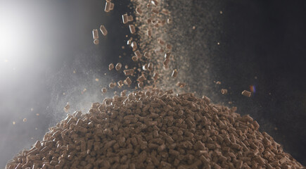 Dry compressed animal feed pellets fall into a heap