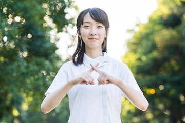 否定のポーズをする白衣の女性