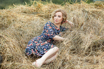 Portrait of a beautiful romantic young woman in the countryside at sunset. young attractive girl in a dress in a rustic style