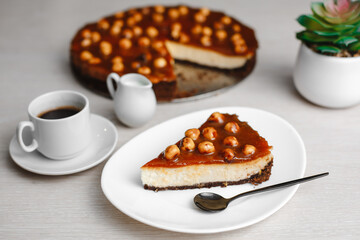 Wonderful caramel cheesecake with homemade caramel, nuts and chocolate. Cheesecake Snickers. Top view, side view. On a white table. Space for text