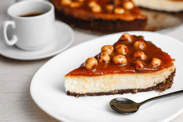 Wonderful caramel cheesecake with homemade caramel, nuts and chocolate. Cheesecake Snickers. Top view, side view. On a white table. Space for text