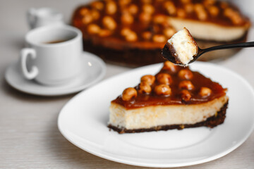 Wonderful caramel cheesecake with homemade caramel, nuts and chocolate. Cheesecake Snickers. Top view, side view. On a white table. Space for text