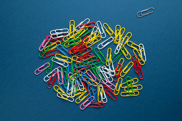 Obraz na płótnie Canvas multi-colored paper clips lie on the table, top view