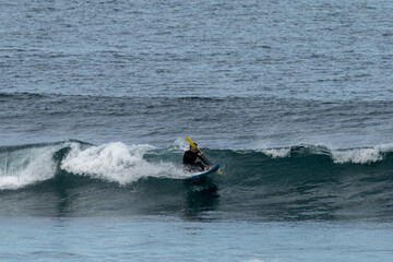 a middle-aged man surfing on a waveski in the Atlantic Ocean