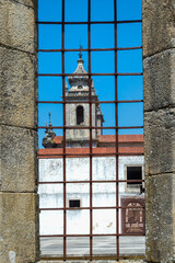 St. Martin of Tibaes Monastery, Church and bell tower viewed through an iron wrought window, Braga,...