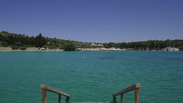 Aegean Sea, Cesme  Sea. View of the blue sea in front of the wooden ladder descending to the sea.