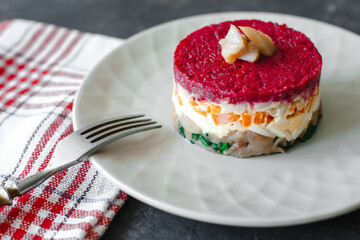 Dressed herring or herring under a fur coat. traditional Russian cuisine. Layered salad composed of diced pickled herring covered with layers of grated boiled vegetables and mayonnaise