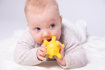 Pretty baby plays on the floor with a toy